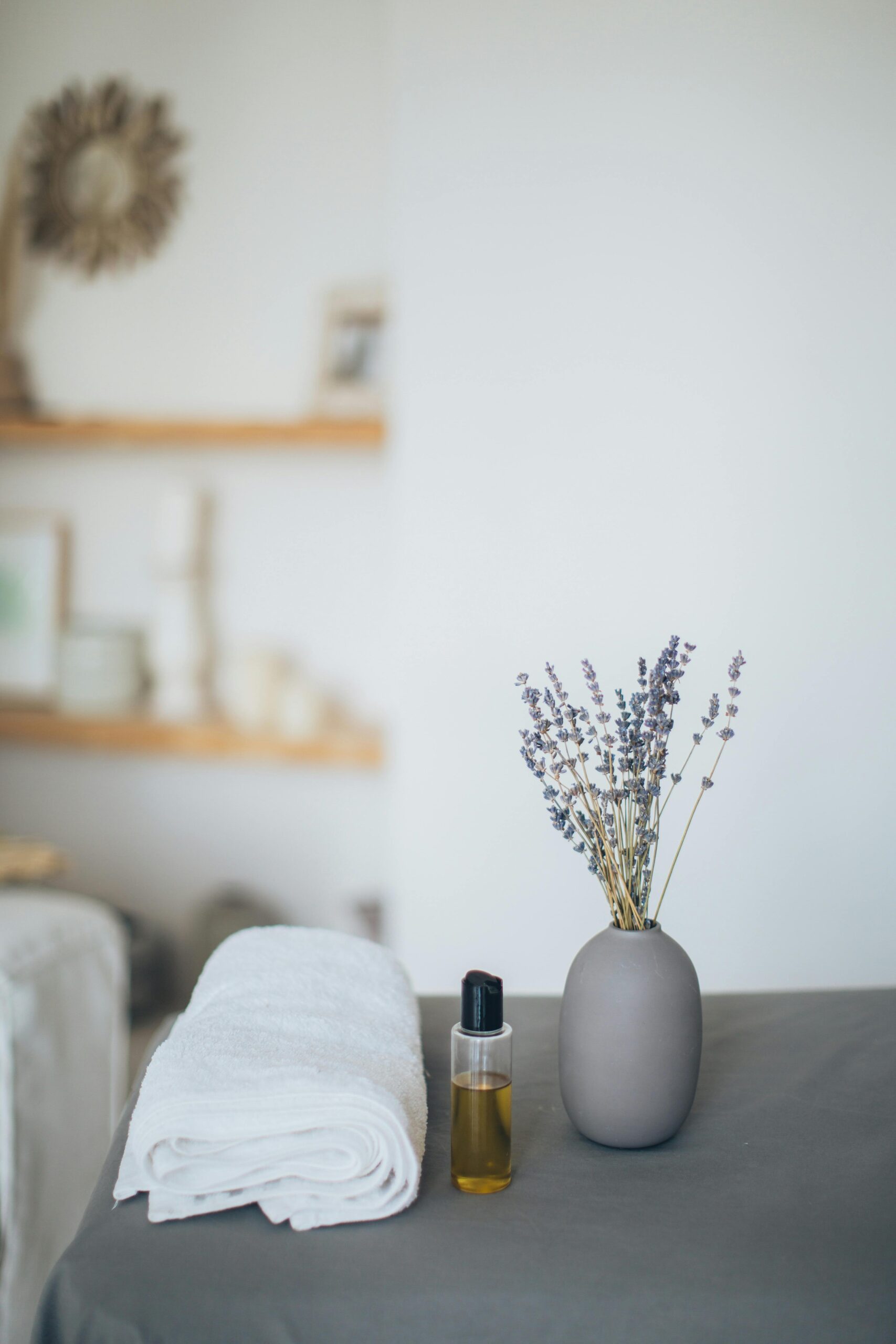Relaxing spa scene featuring lavender, towel, and oil for a calming experience.